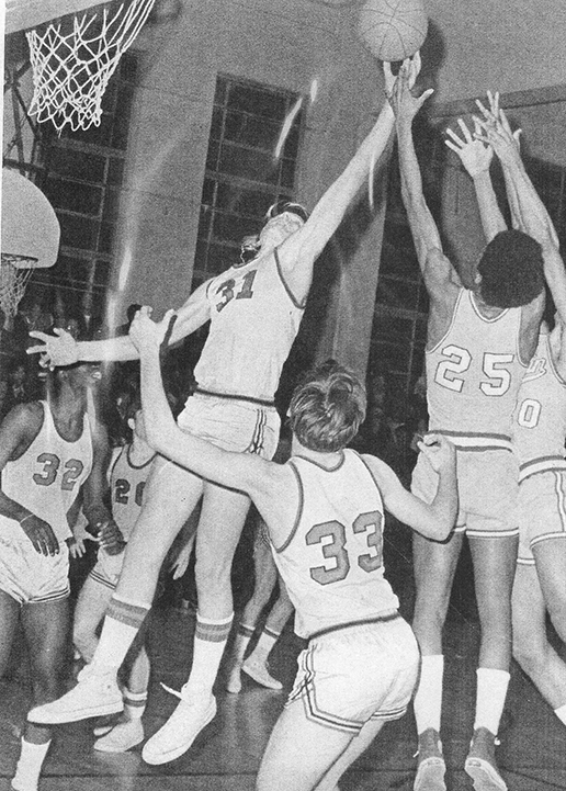 Black and White picture of a basketball player blocking a shot
