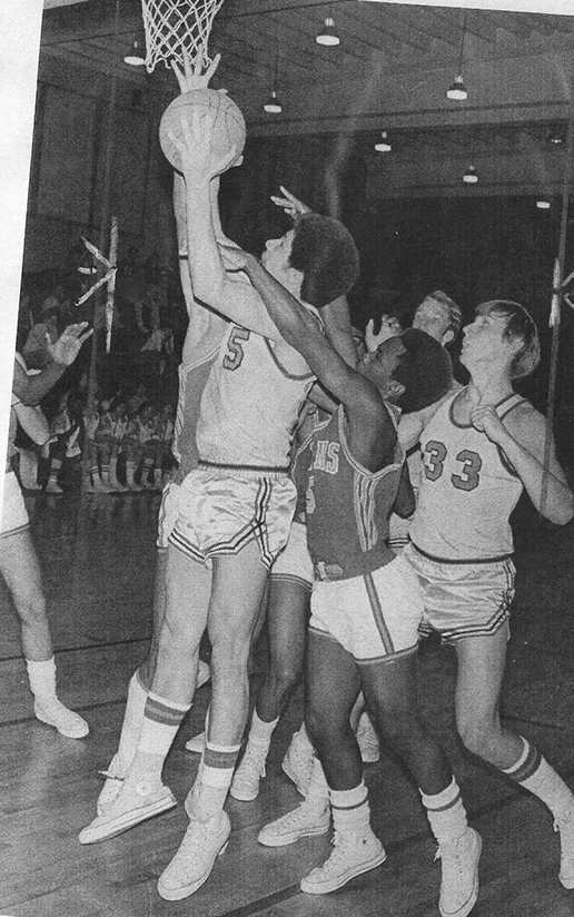 Black and White picture of a basketball player going in for a dunk